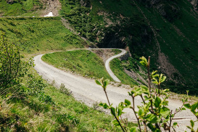Road amidst green landscape against sky
