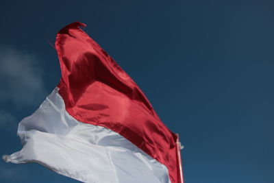 Low angle view of flag against blue sky