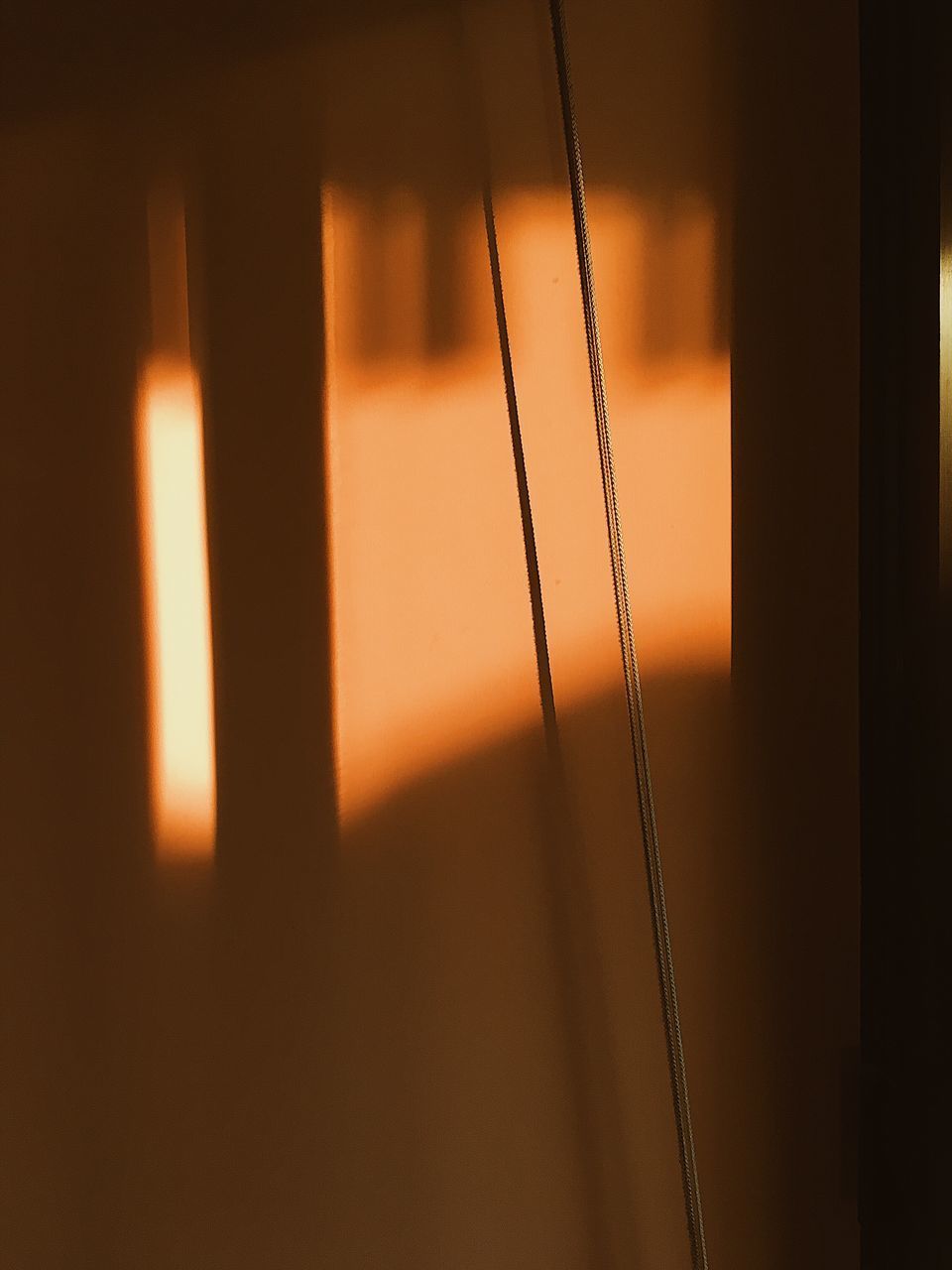 CLOSE-UP OF GLASS WINDOW AGAINST ORANGE SKY