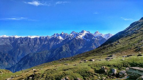 Scenic view of snowcapped mountains against blue sky