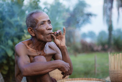 Old man are smoking in the countryside of thailand.