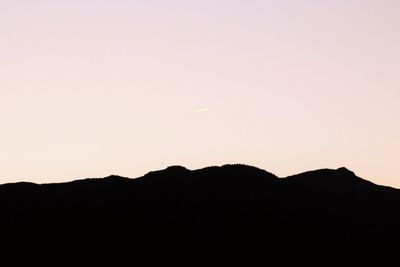 Silhouette mountains against clear sky