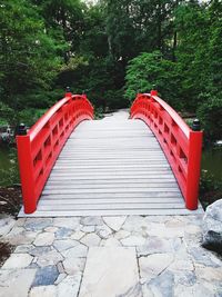 Red wooden footbridge on footpath in park
