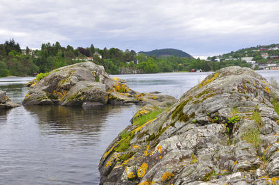 Scenic view of rocks by river against sky