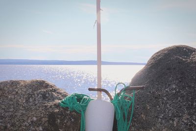 Low section of person by sea against sky