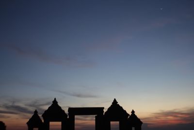 Silhouette buildings against sky at sunset