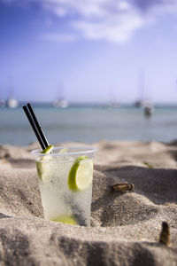 High angle view of drink on table at beach against sky