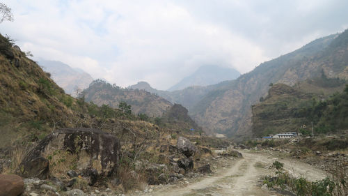 Scenic view of road amidst mountains against sky