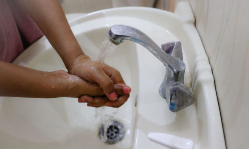 Midsection of woman in bathroom at home