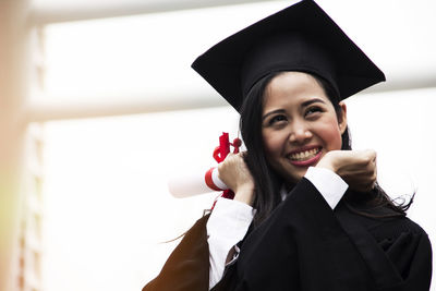 Cheerful young woman in graduation gown