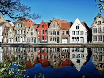 Reflection of buildings in canal against sky