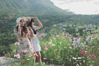 Woman standing by flowering plants