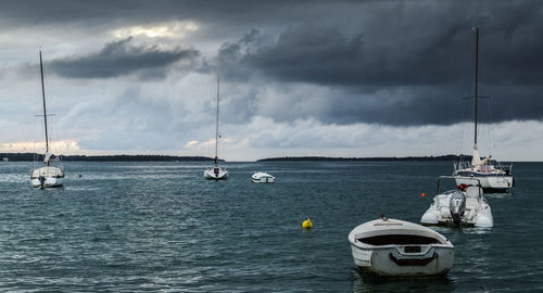 Boats sailing in sea against sky