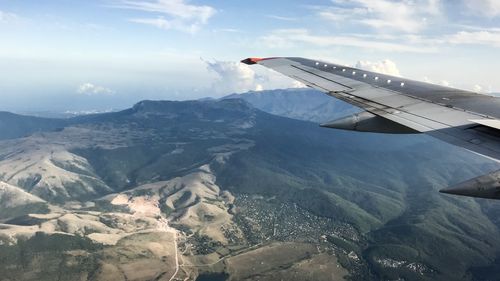 Airplane flying over snowcapped mountains against sky