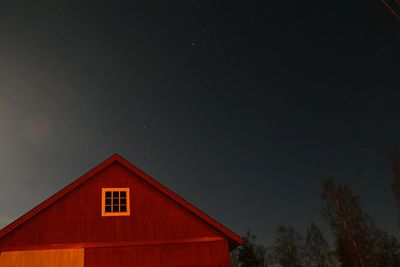 Low angle view of red house against sky at night