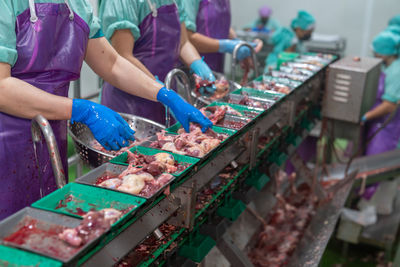 Worker separate chicken offal and clean in poultry process line.