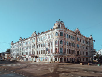 Buildings in city against clear blue sky