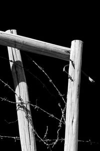 Low angle view of wooden fence against tree at night