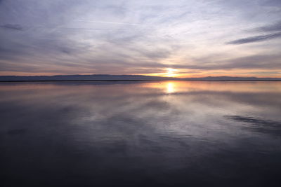 Scenic view of calm lake against cloudy sky