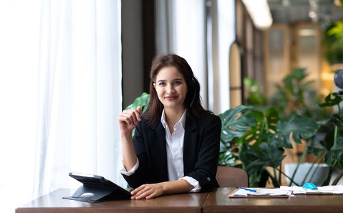 Portrait of a beautiful young woman sitting on table