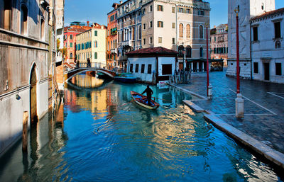 Man on gondola amidst buildings