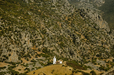 Landscape photo of a mosque up the hill with mountains  