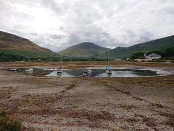 People on lake against mountain range