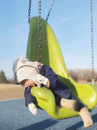 Cute baby girl sleeping in swing at playground