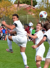 Men playing soccer on field