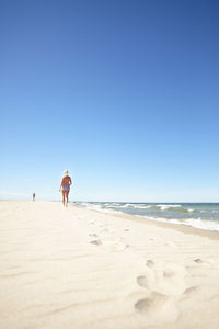 Woman walking on sandy beach