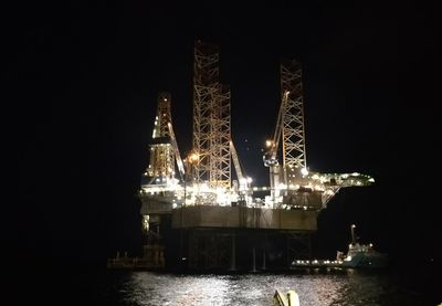 Illuminated ship by sea against sky at night