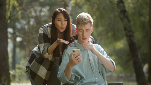 Man on wheelchair talking on video call with girlfriend at park