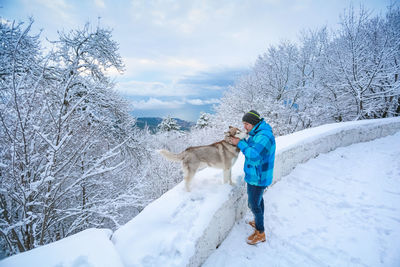 Full length of man standing on snow covered tree