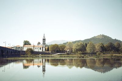 Reflection of building in lake against clear sky