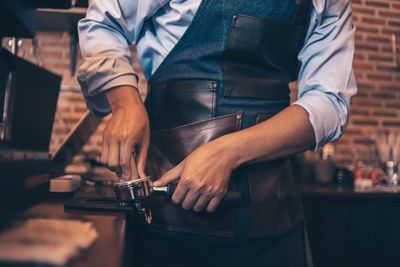 Midsection of man working on barbecue grill