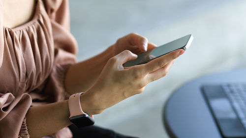 Midsection of man using mobile phone