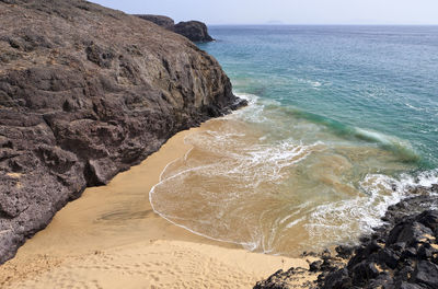 Scenic view of rocks on beach against sky