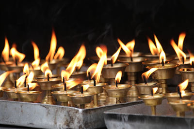 Close-up of burning candles in temple