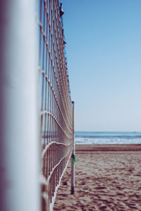 Close-up of volleyball net against sea at beach