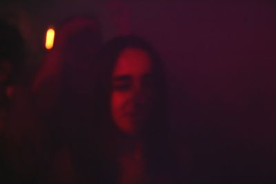 Close-up of young woman against black background