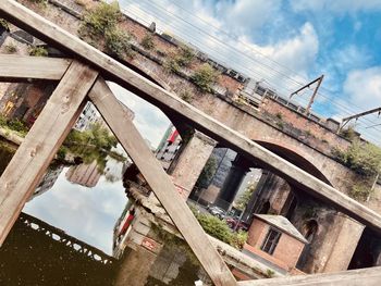 Low angle view of tree by building against sky