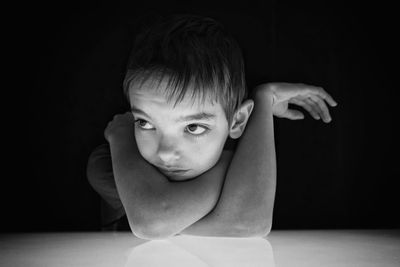 Close-up portrait of boy against black background