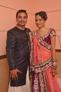 Portrait of smiling young couple standing against wall