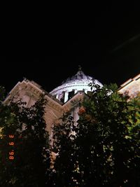 Low angle view of illuminated building against sky at night