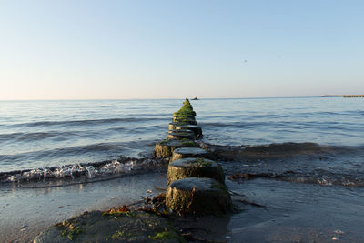 Statue on beach against clear sky