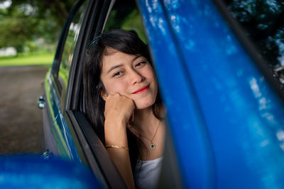 Portrait of smiling young woman in car