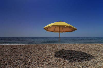 Lifeguard hut on beach against clear blue sky