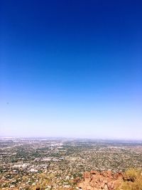 Aerial view of cityscape against blue sky