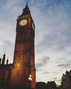 Low angle view of clock tower against cloudy sky