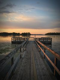 Dock over lake against sky during sunset